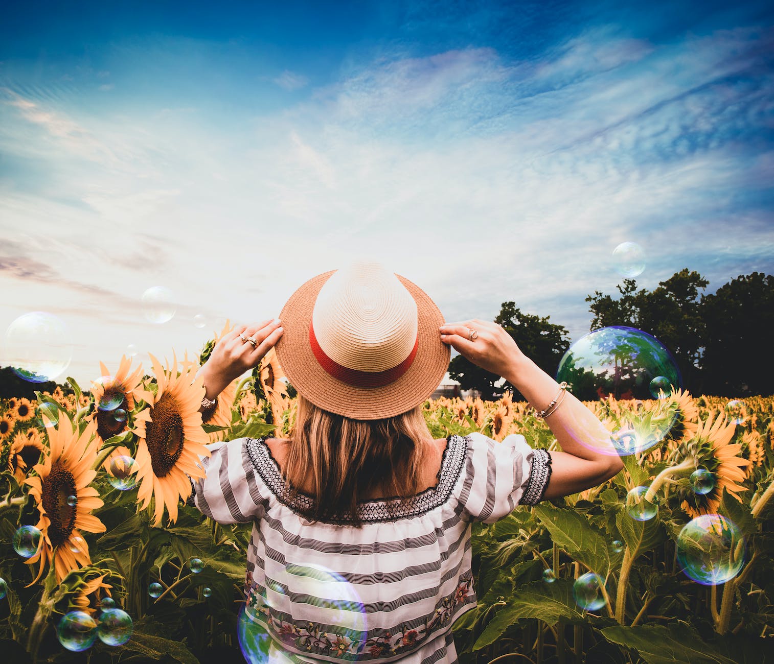 standing woman surrounded of sunflowers